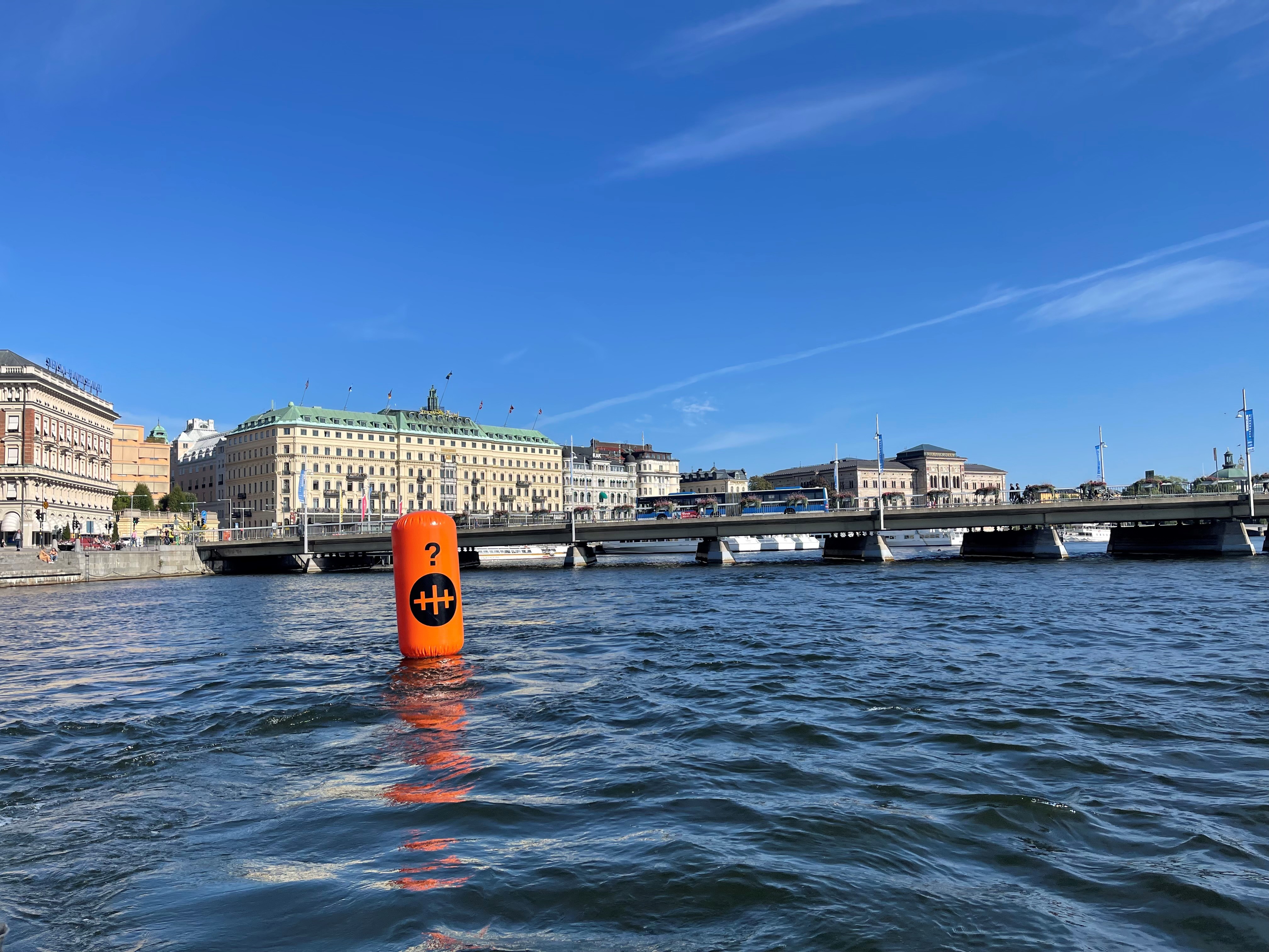 Orangefärgad boj på Stockholms ström, Grand Hotell i bakgrunden