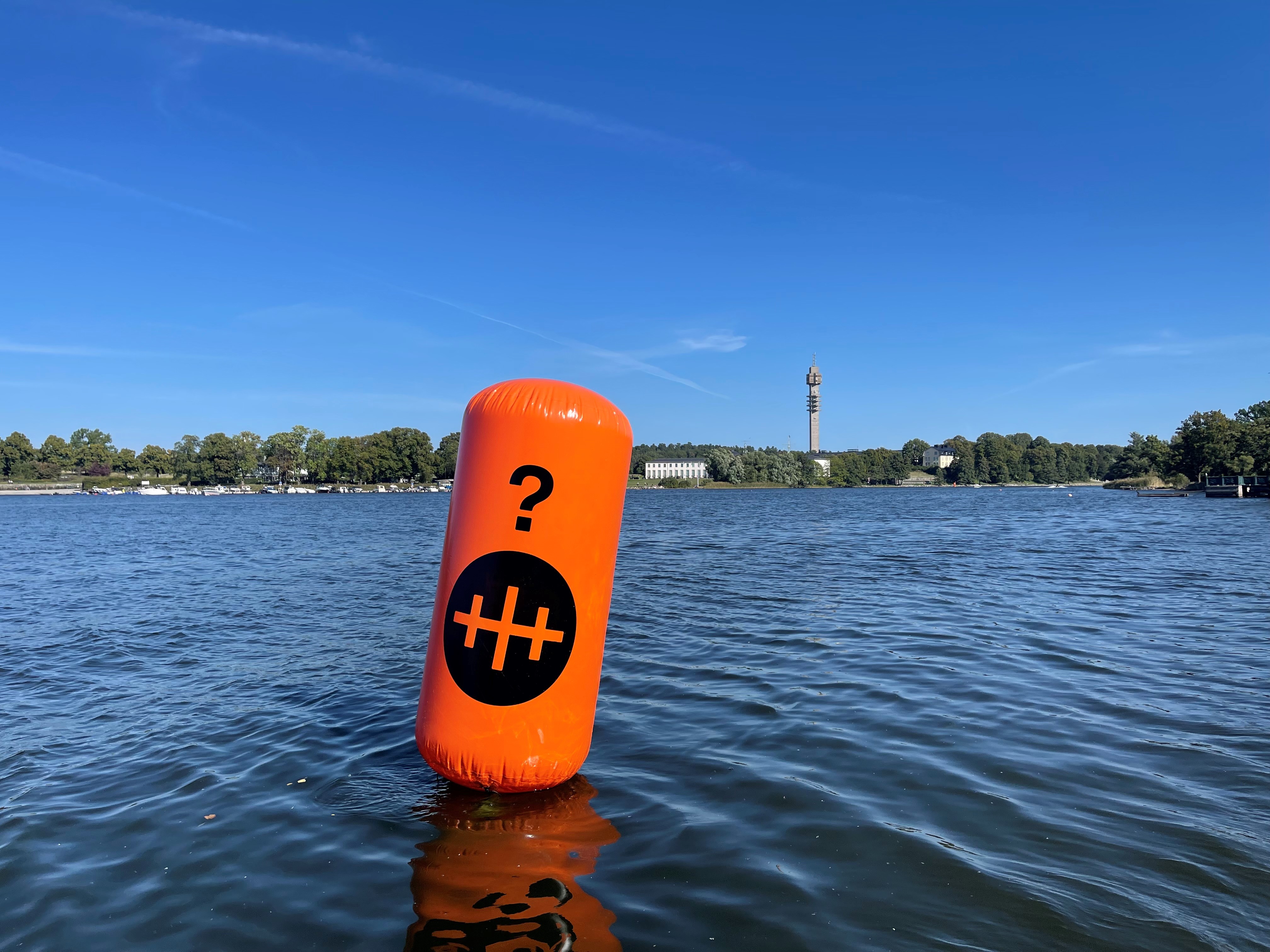 Orangefärgad boj på Stockholms vatten, Kaknästornet i bakgrunden